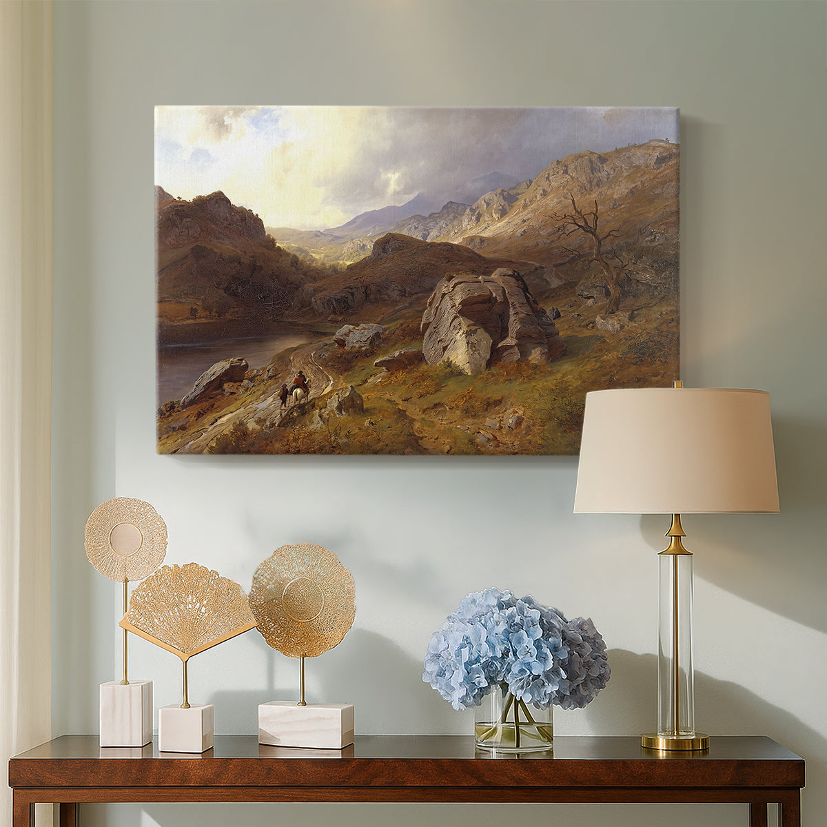Canvas art print featuring a natural landscape with rolling terrain and distant peaks, displayed above a styled console table