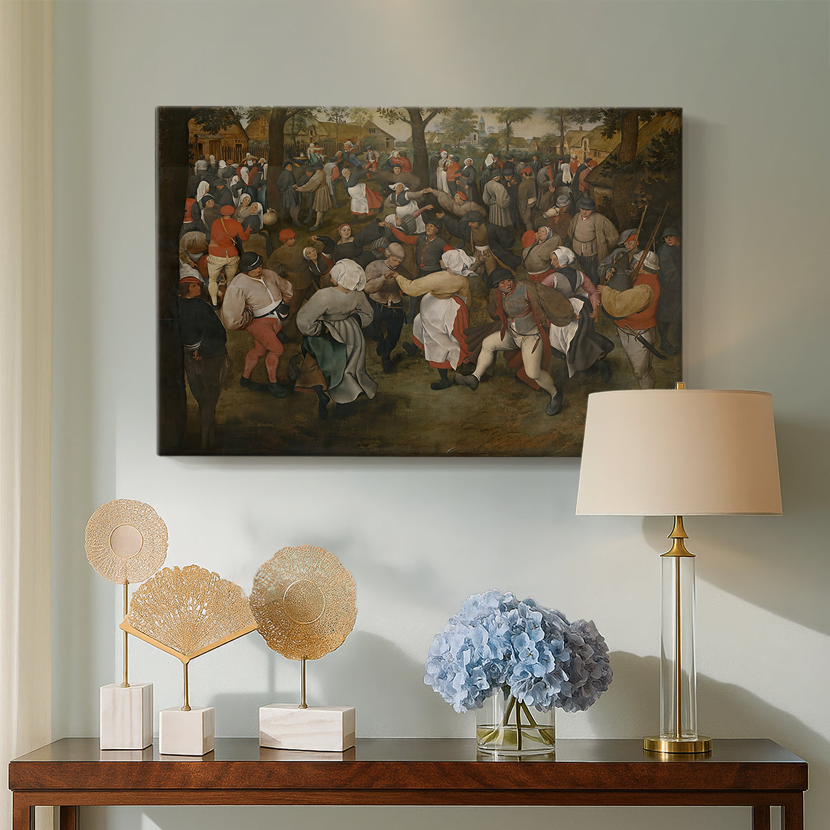 Canvas art print featuring an expressive depiction of communal celebration in village setting, displayed above a styled console table