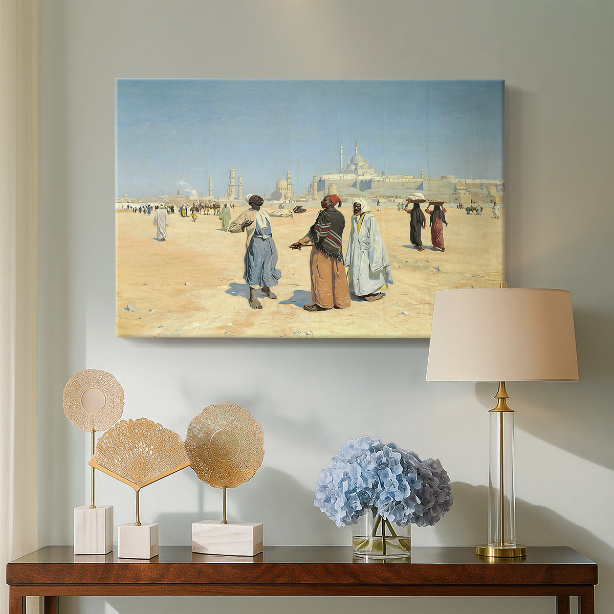 Canvas art print featuring a scene of figures crossing sandy terrain with distant skyline, displayed above a styled console table