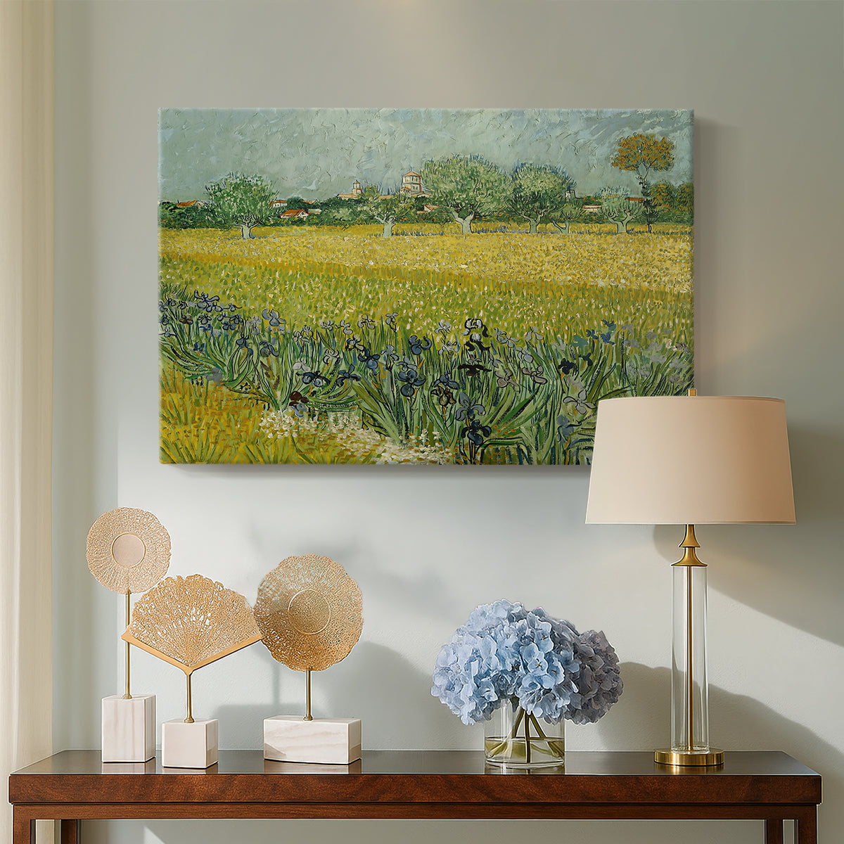 Canvas art print featuring a post-impressionist countryside scene with flowers and terrain, displayed above a styled console table