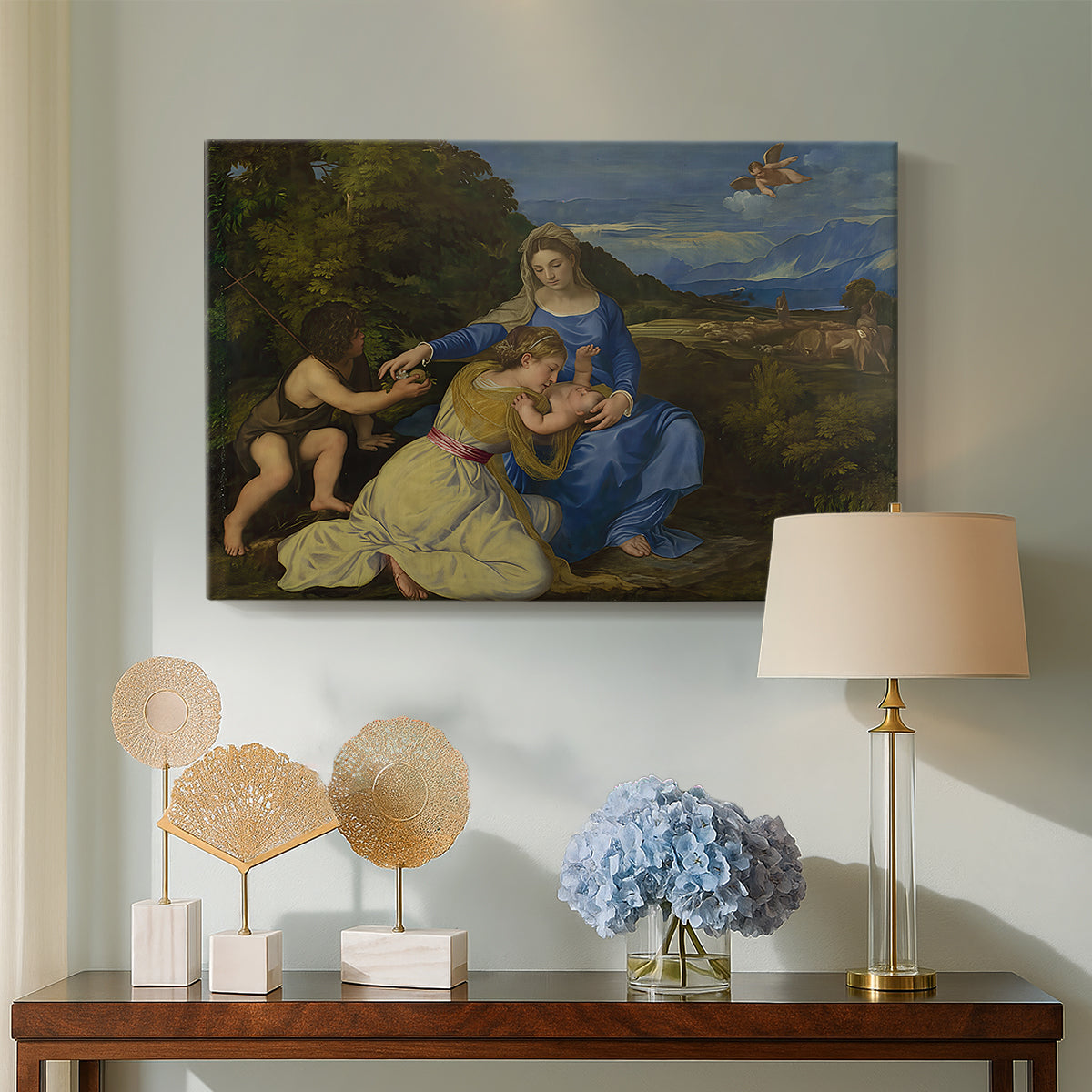 Canvas art print featuring a Renaissance religious composition with seated figures in natural setting, displayed above a styled console table