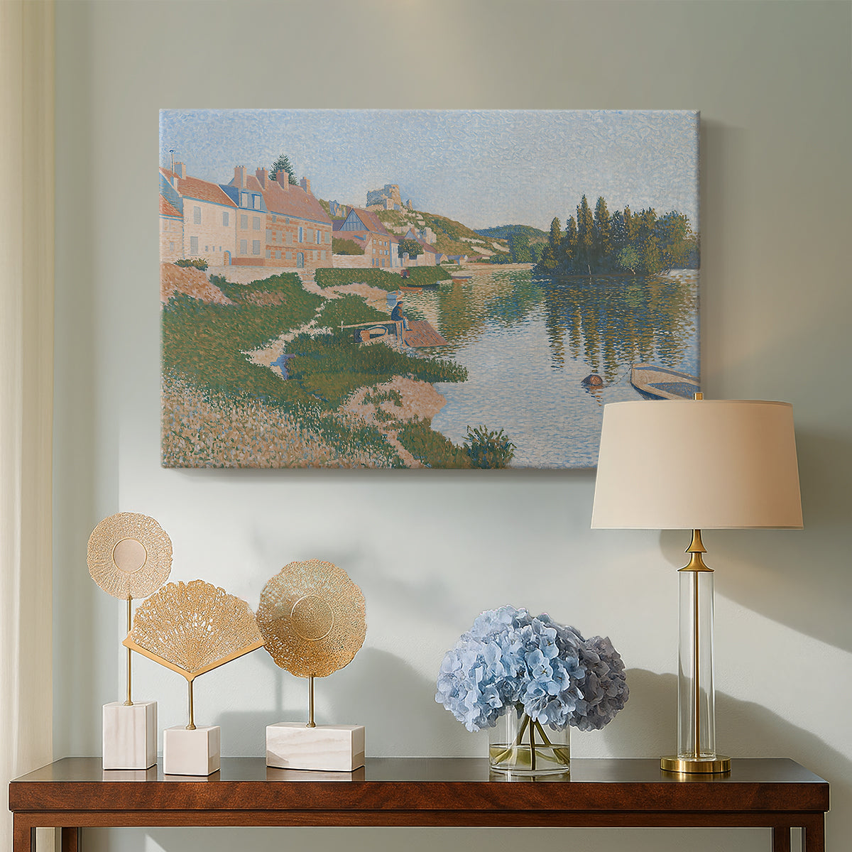Canvas art print featuring a pointillist town next to a riverbank, displayed above a styled console table