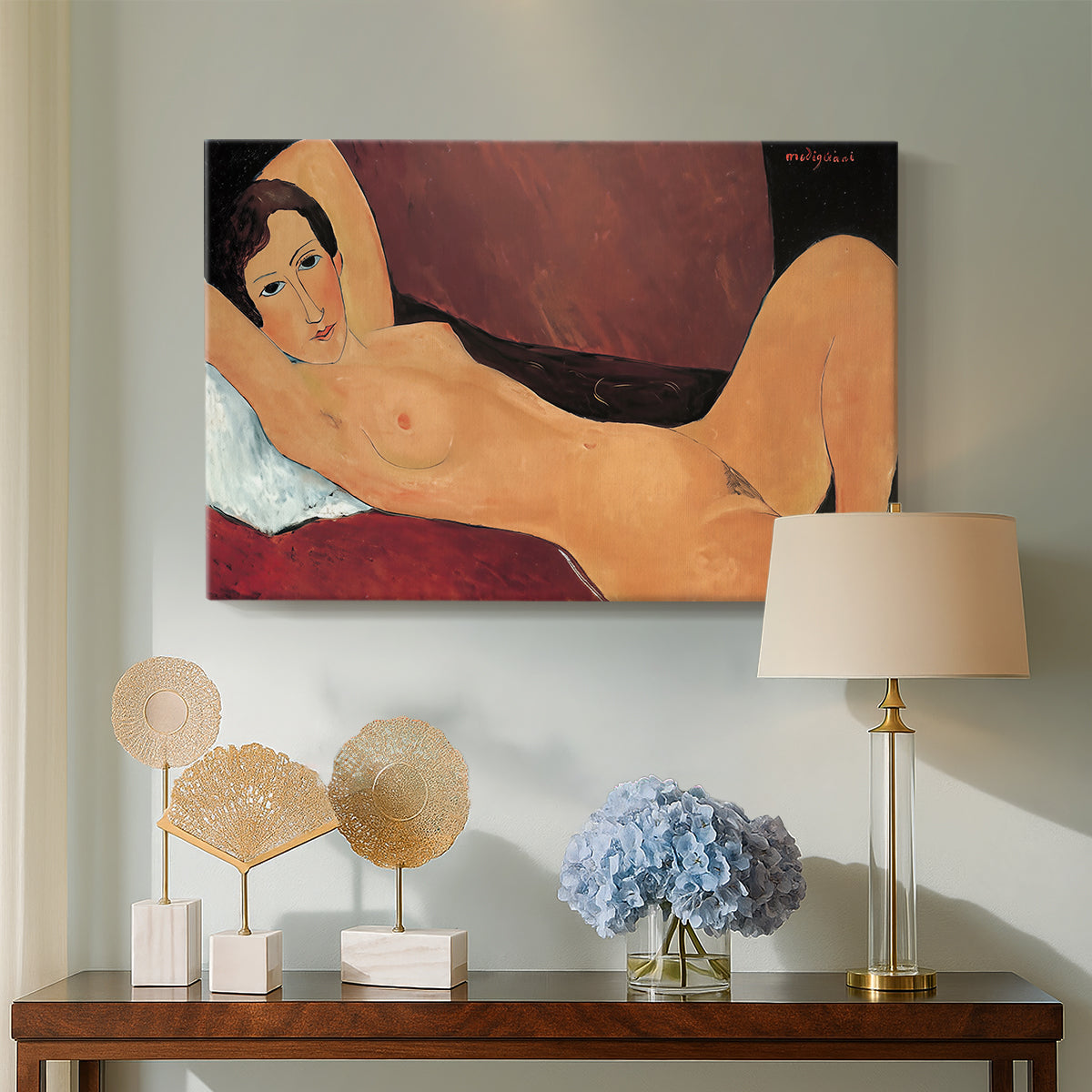 Canvas art print featuring a stylized female nude with elongated proportions resting on couch, displayed above a styled console table