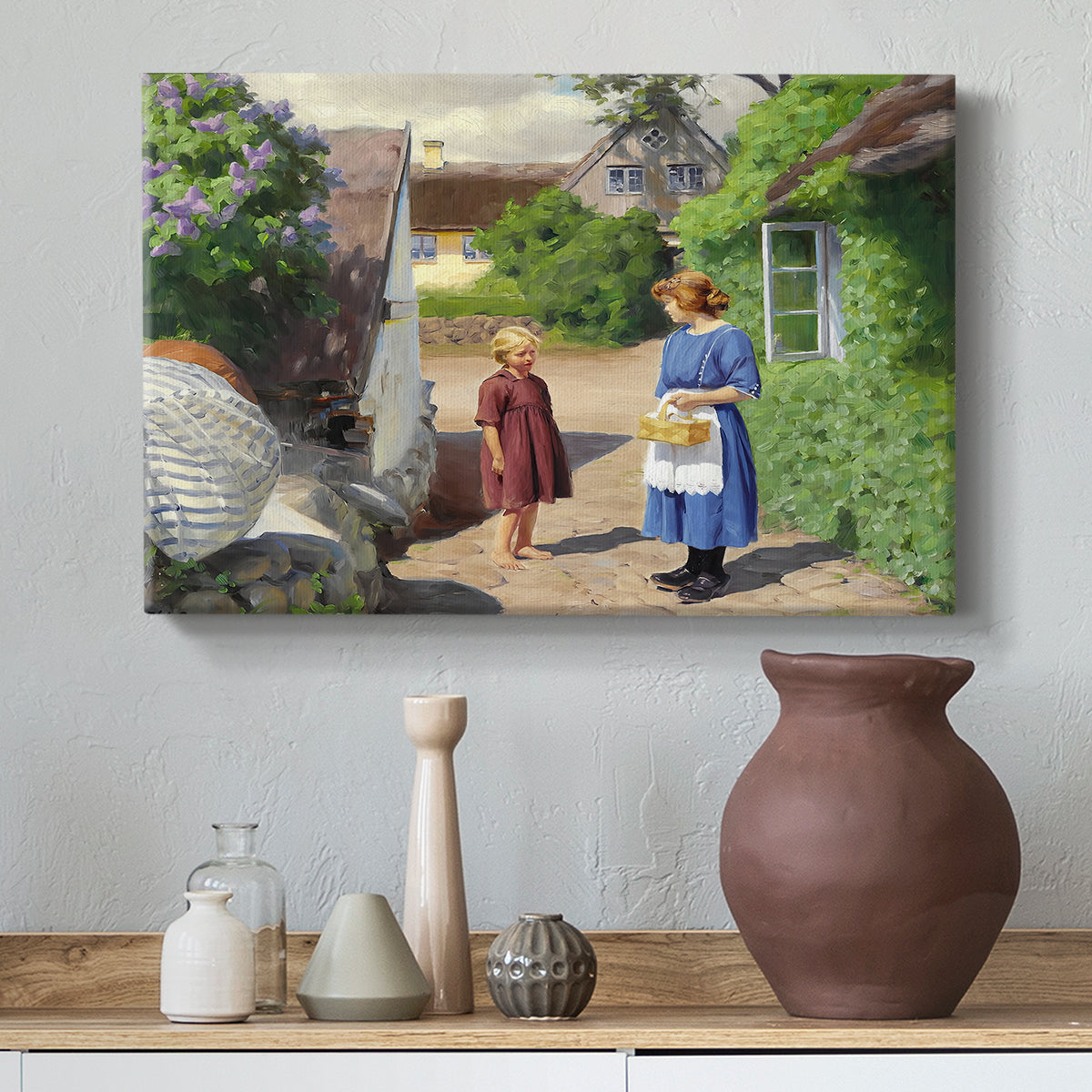 Canvas art print featuring a countryside setting with homes and people outdoors, styled above a decorative console