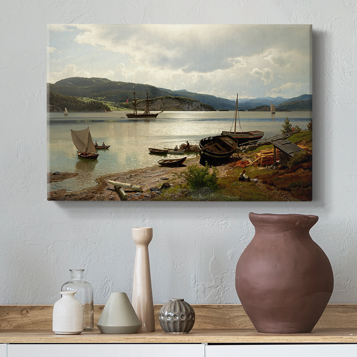 Canvas art print featuring a coastal landscape with figures engaged in daily activity, styled above a decorative console