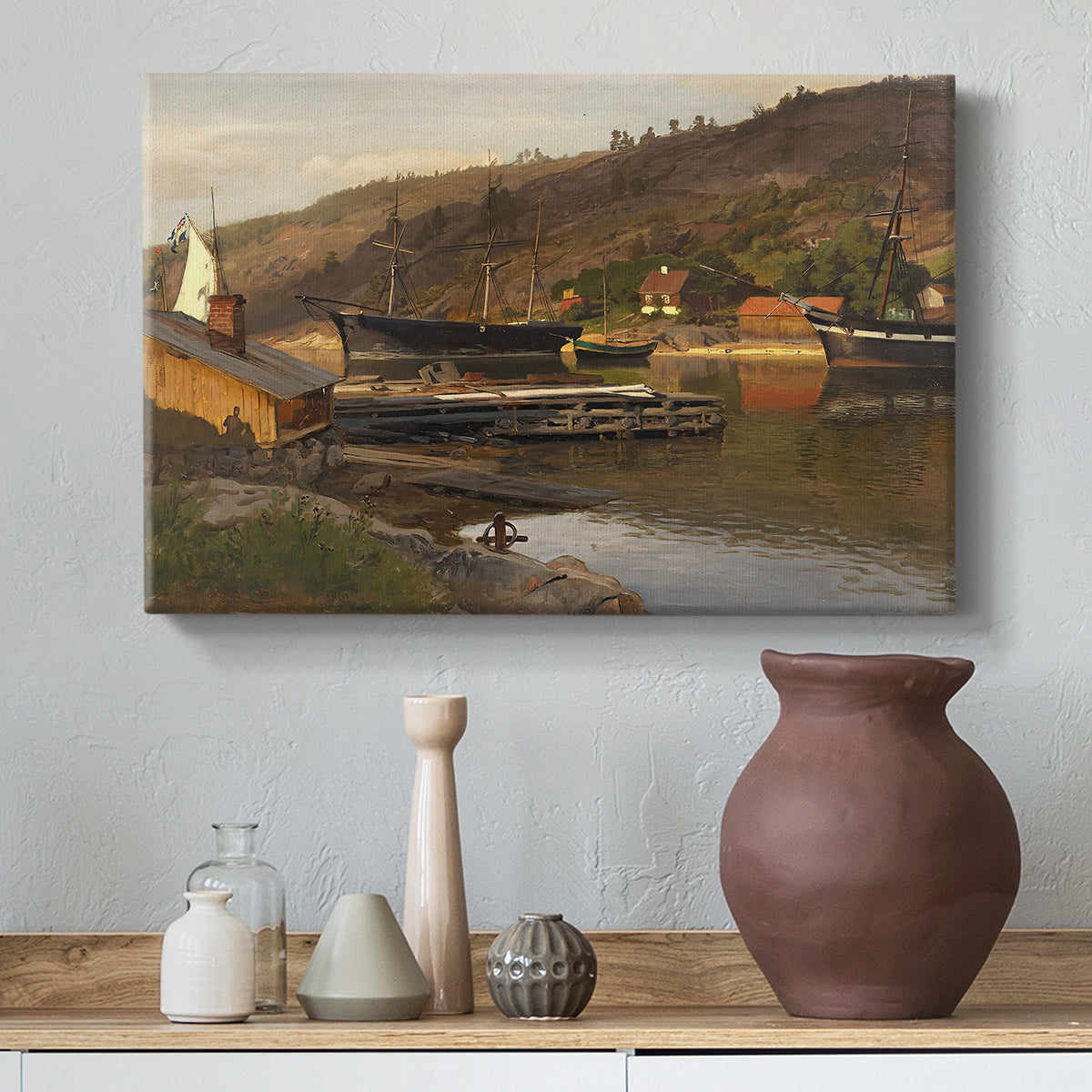 Canvas art print featuring a waterfront setting with village structures and reflections, styled above a decorative console