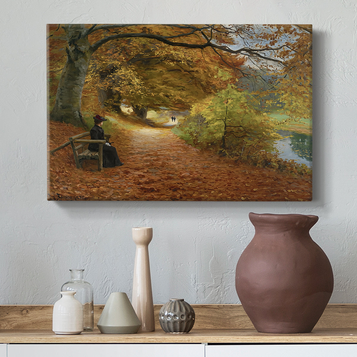 Canvas art print featuring a countryside path lined with trees and warm seasonal colors, styled above a decorative console