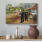 Canvas art print featuring a rustic village setting with people interacting in open space, styled above a decorative console