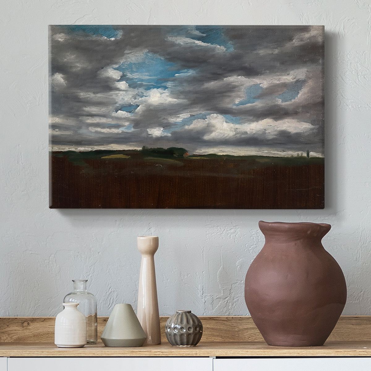 Canvas art print featuring an expansive countryside with cloud cover, styled above a decorative console
