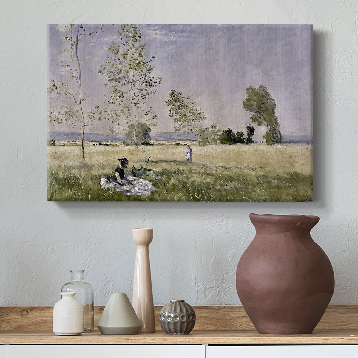 Canvas art print featuring a sunlit meadow with woman surrounded by greenery, styled above a decorative console