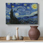 Canvas art print featuring a post-impressionist night scene with village beneath moving sky, styled above a decorative console