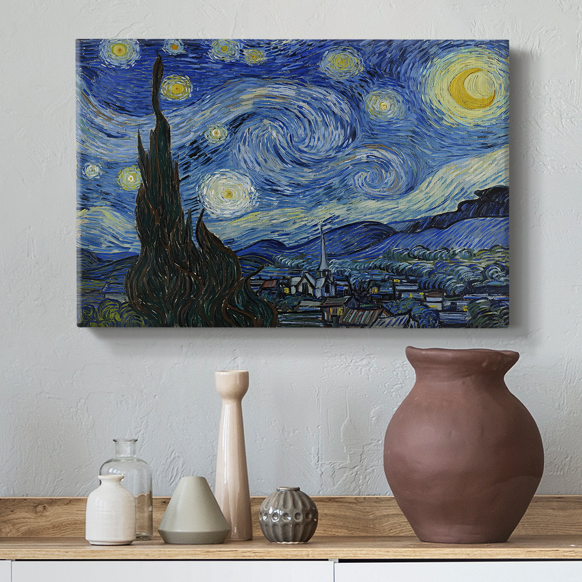 Canvas art print featuring a post-impressionist night scene with village beneath moving sky, styled above a decorative console