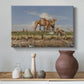 Canvas art print featuring a landscape featuring river, animals, and activity, styled above a decorative console