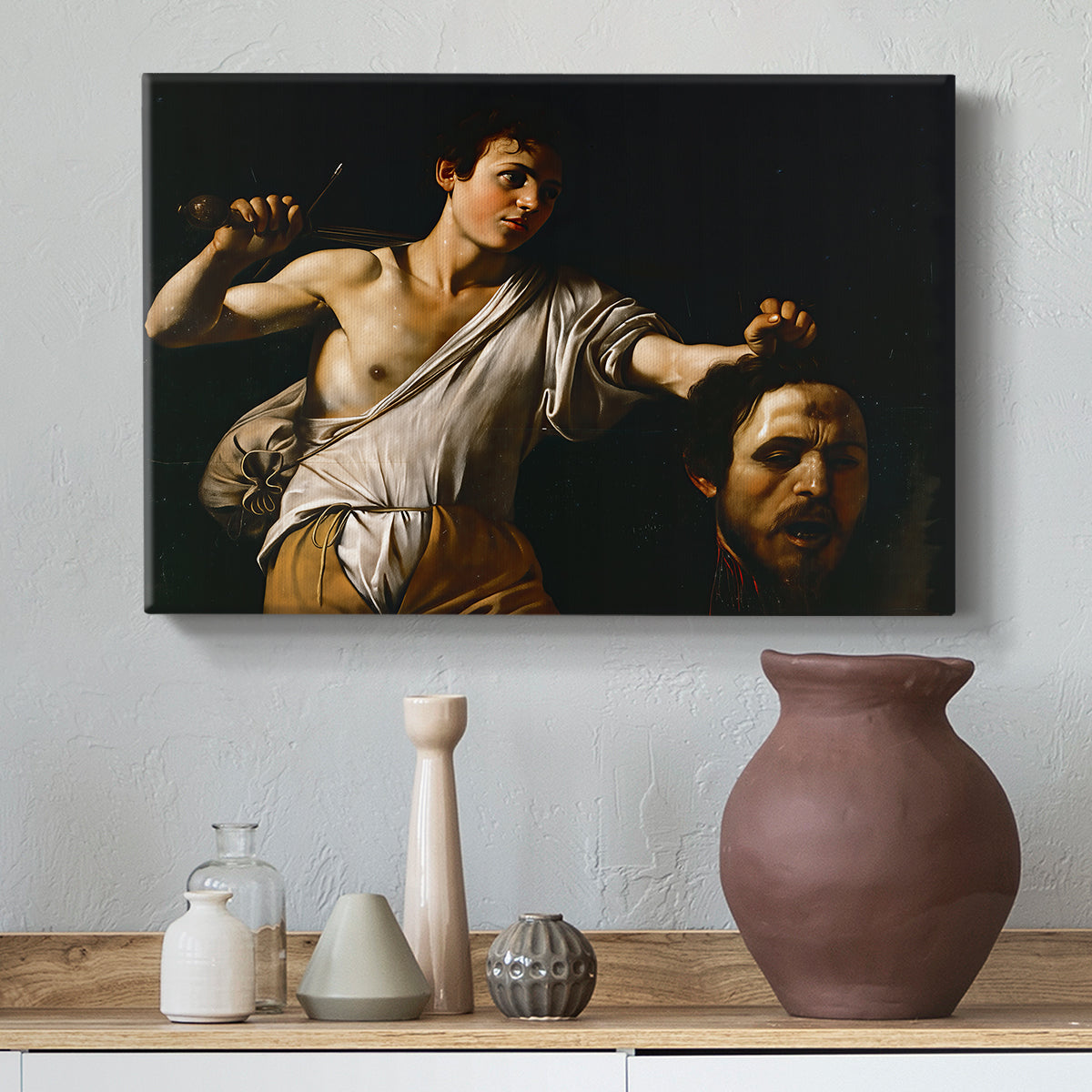 Canvas art print featuring a Baroque depiction of youth holding severed head in shadowy setting, styled above a decorative console