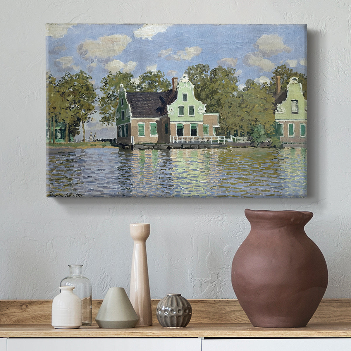 Canvas art print featuring a peaceful canal scene with houses mirrored in water, styled above a decorative console
