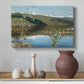 Canvas art print featuring an expansive view of land and water beneath approaching storm clouds, styled above a decorative console