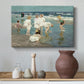 Canvas art print featuring an impressionist coastal view of families enjoying seaside water, styled above a decorative console