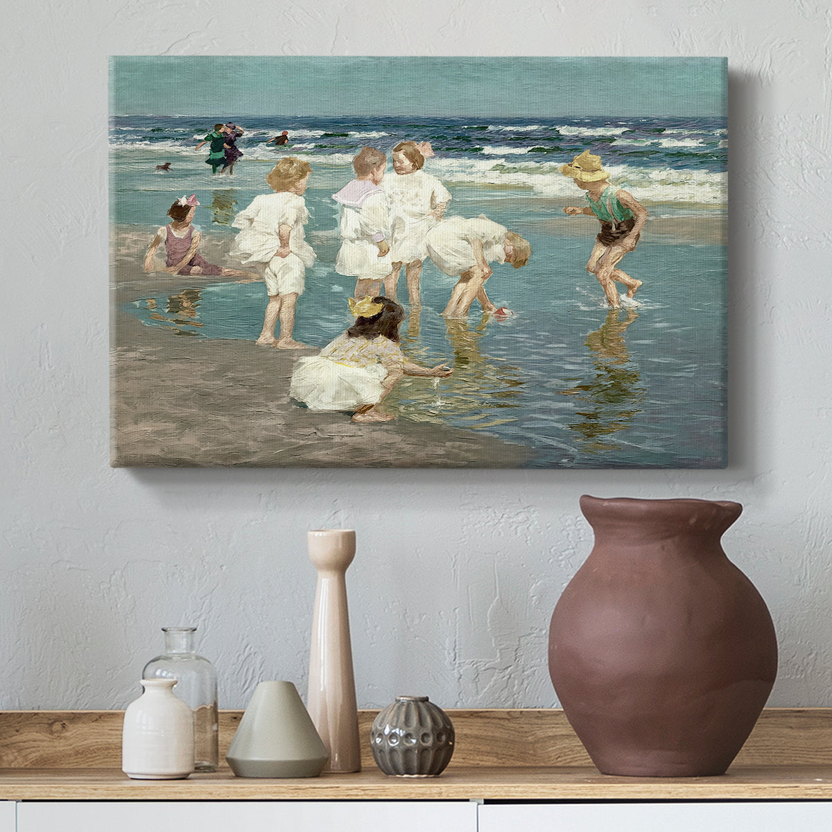 Canvas art print featuring an impressionist coastal view of families enjoying seaside water, styled above a decorative console