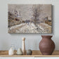 Canvas art print featuring a quiet boulevard blanketed in snow with distant figures, styled above a decorative console