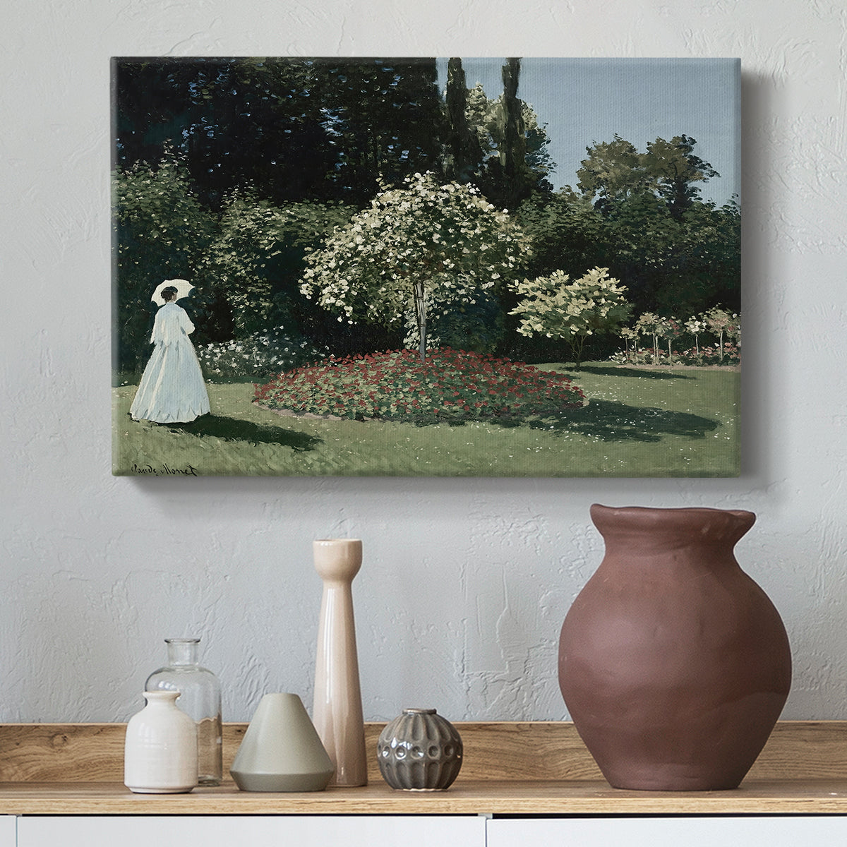 Canvas art print featuring an elegant woman posed outdoors among blooming plants, styled above a decorative console