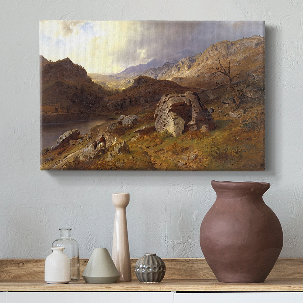 Canvas art print featuring a natural landscape with rolling terrain and distant peaks, styled above a decorative console