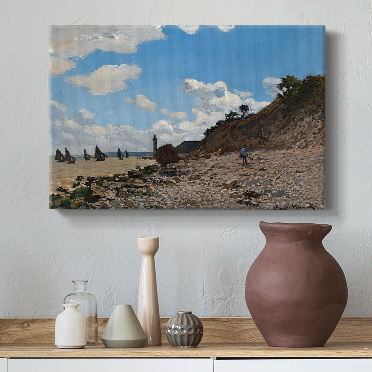 Canvas art print featuring a sandy beach with figures relaxing near water's edge, styled above a decorative console