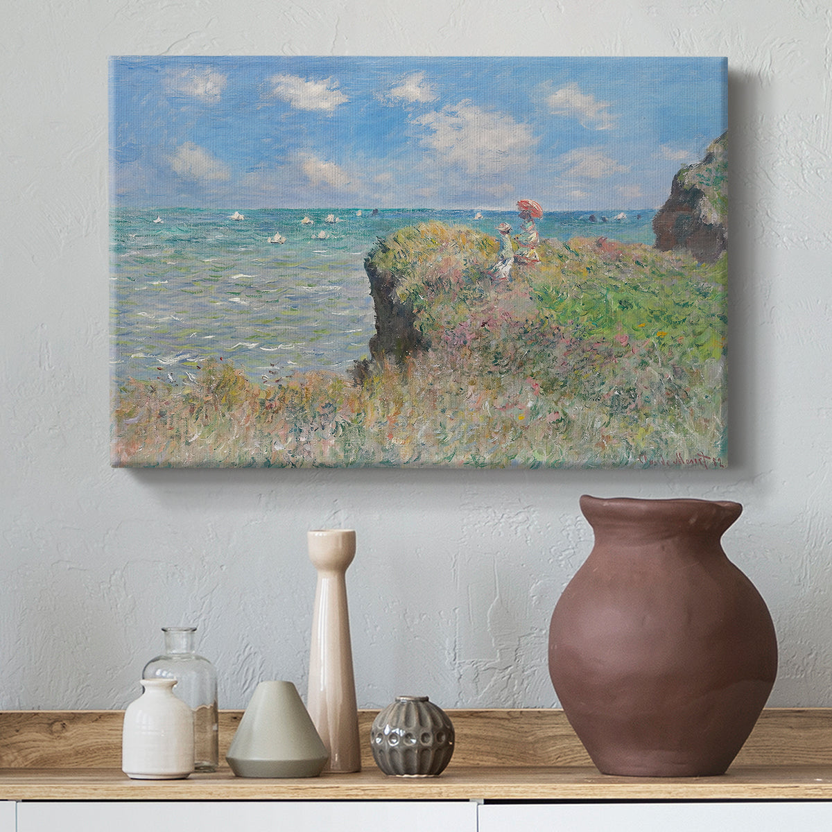 Canvas art print featuring a coastal cliff scene with grass, wind, and expansive sea view, styled above a decorative console