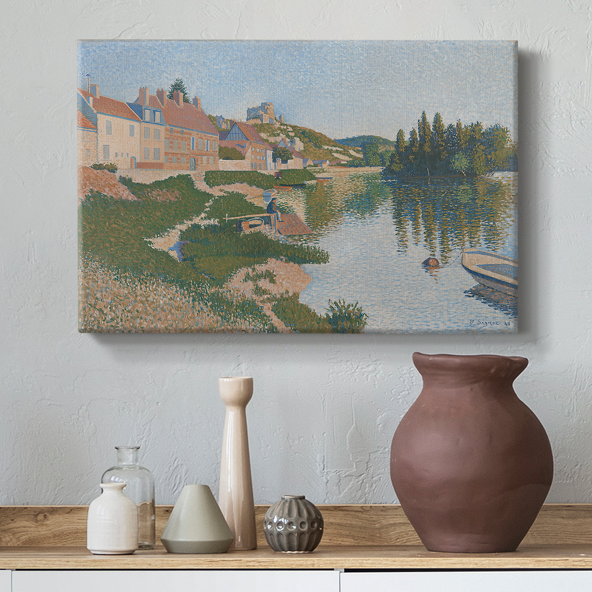 Canvas art print featuring a pointillist town next to a riverbank, styled above a decorative console