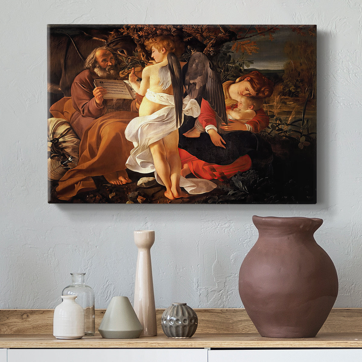 Canvas art print featuring a peaceful religious moment with figures reclining in natural setting, styled above a decorative console