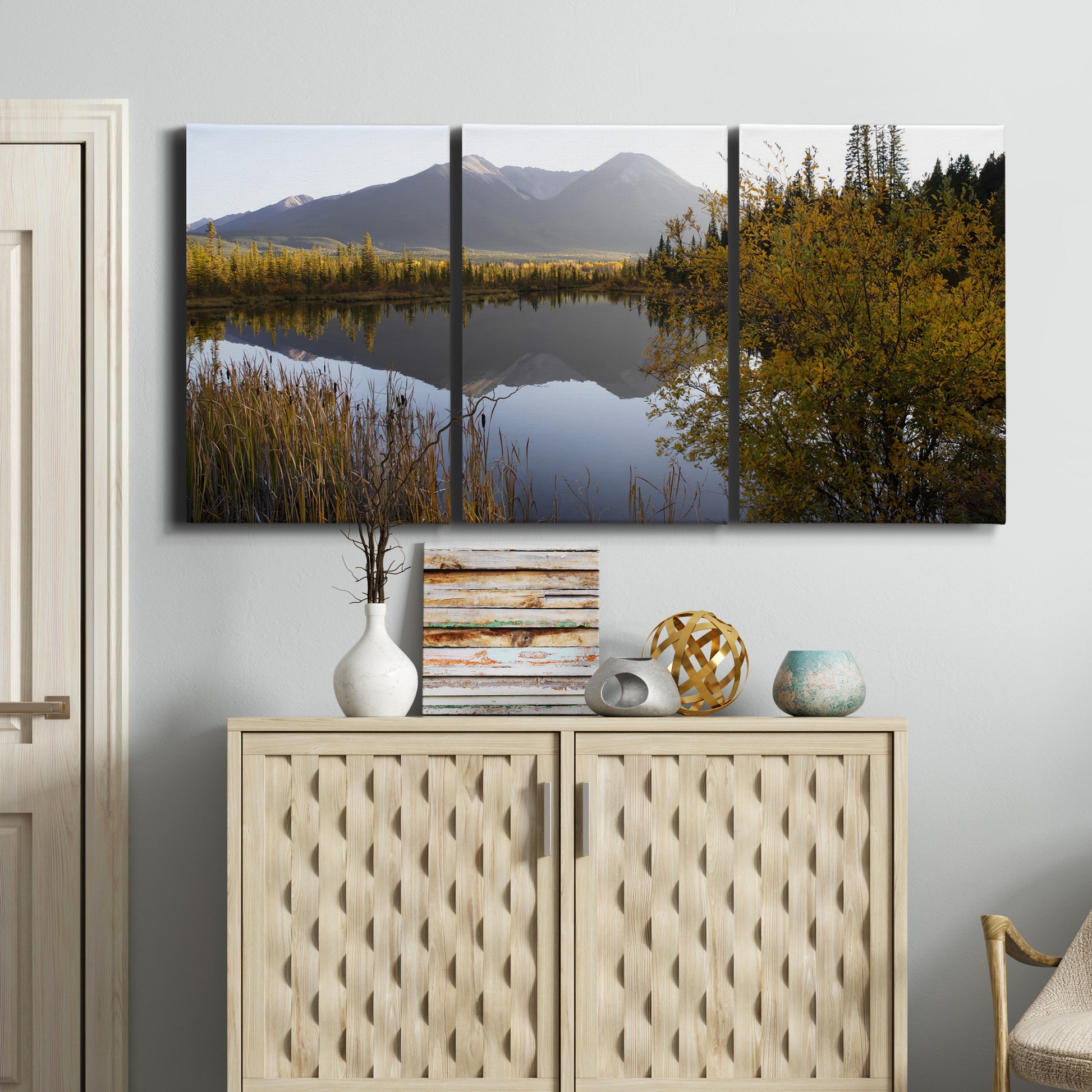 Three-panel canvas wall art featuring low light river photography, displayed above a cabinet in an entryway.