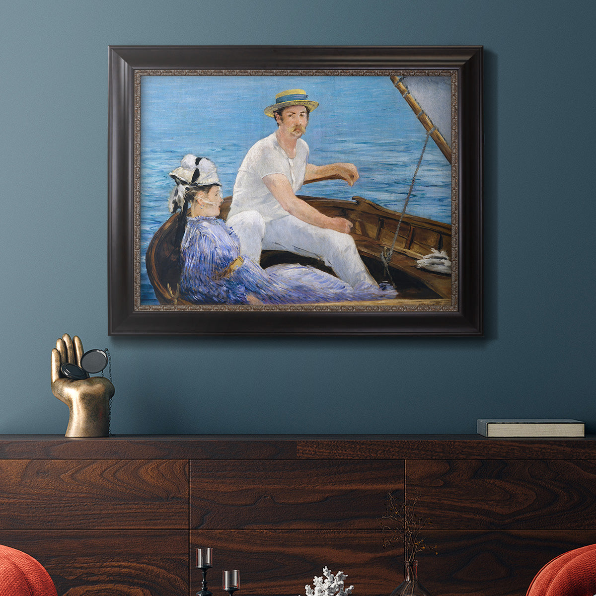 Impressionist leisure boating scene by Édouard Manet in an ornate black frame with gilded inner detail displayed in a dark-toned interior setting.