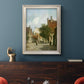 Rustic European street scene painting by Adriaan Eversen in an ornate champagne frame displayed in a dark-toned interior setting.