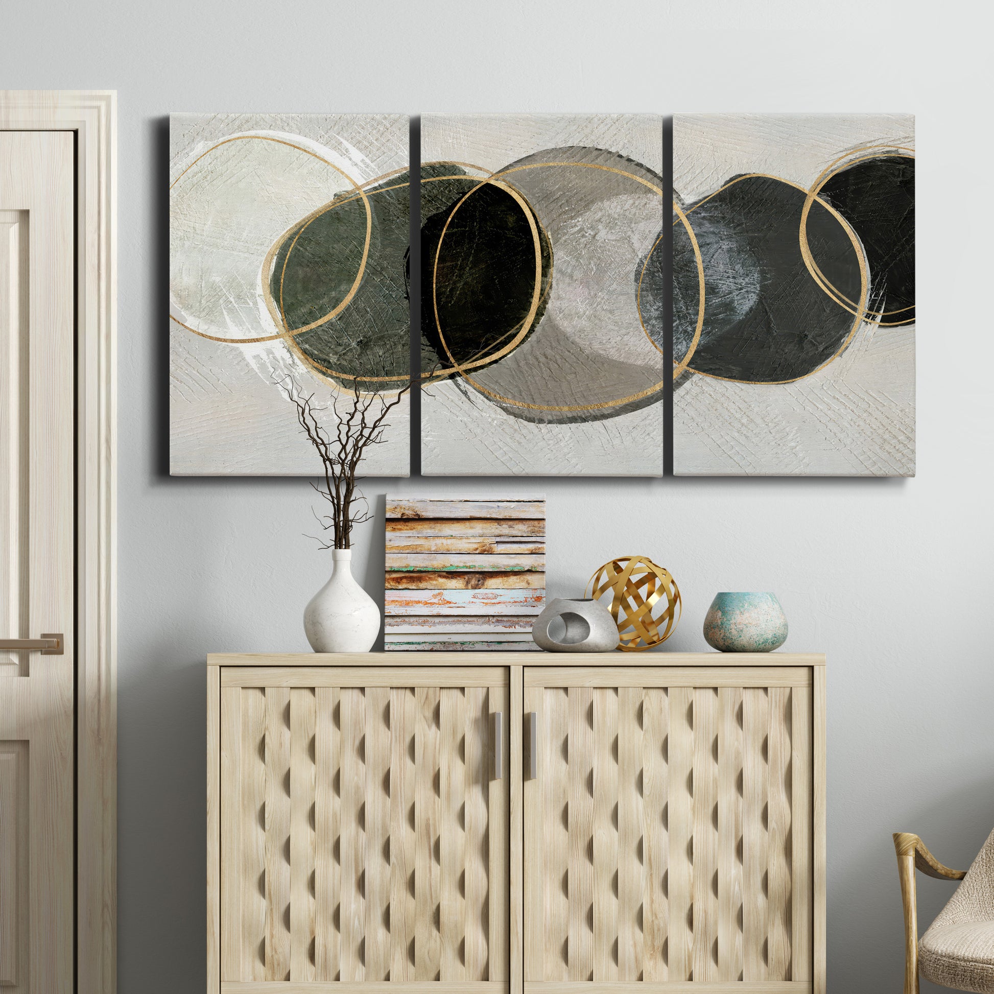 Three-panel canvas wall art featuring smooth abstract river stone forms, displayed above a cabinet in an entryway.