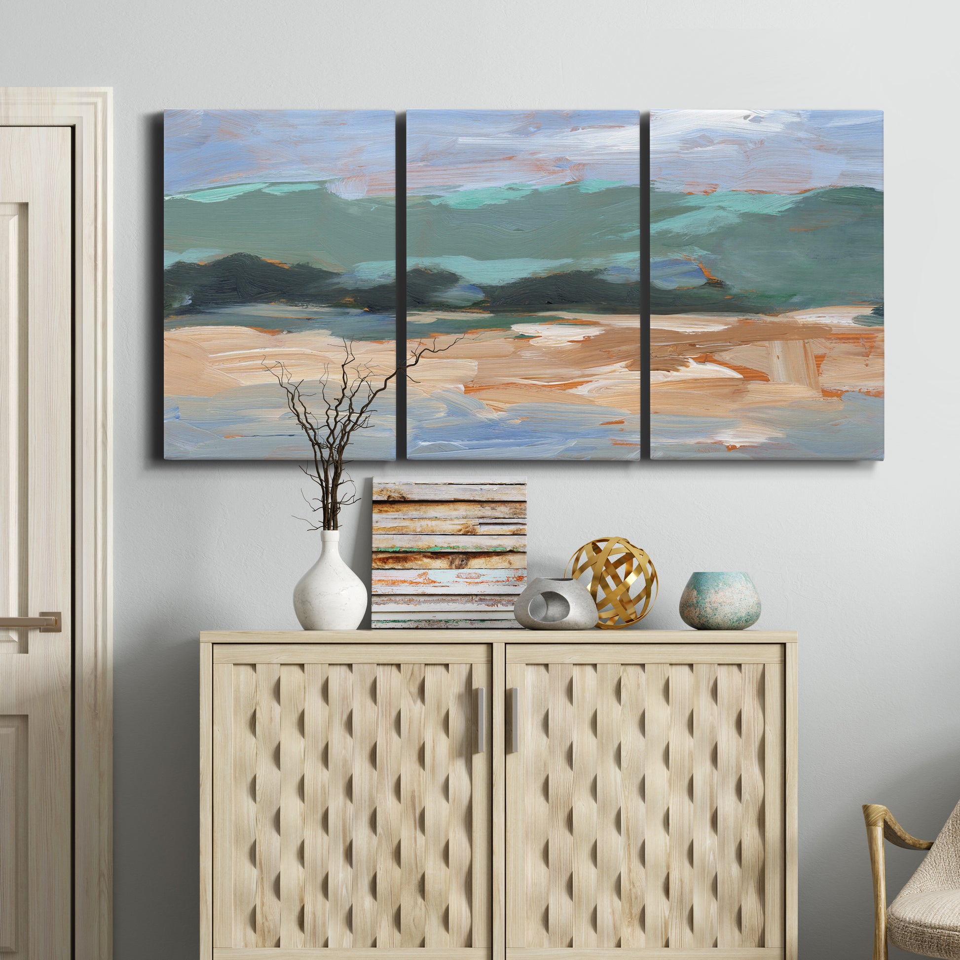 Three-panel canvas wall art featuring abstract landscape composition study, displayed above a cabinet in an entryway.