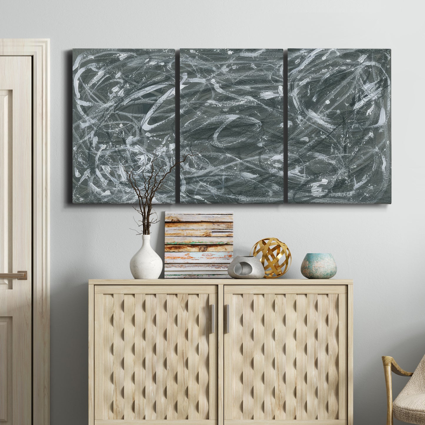 Three-panel canvas wall art featuring abstract view through window forms, displayed above a cabinet in an entryway.