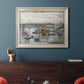 Impressionist river bridge scene on an overcast day by Claude Monet in an ornate champagne frame displayed in a dark-toned interior setting.