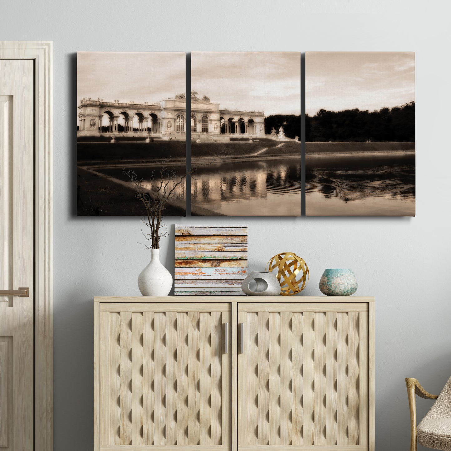 Three-panel canvas wall art featuring monochrome historic pavilion photograph, displayed above a cabinet in an entryway.