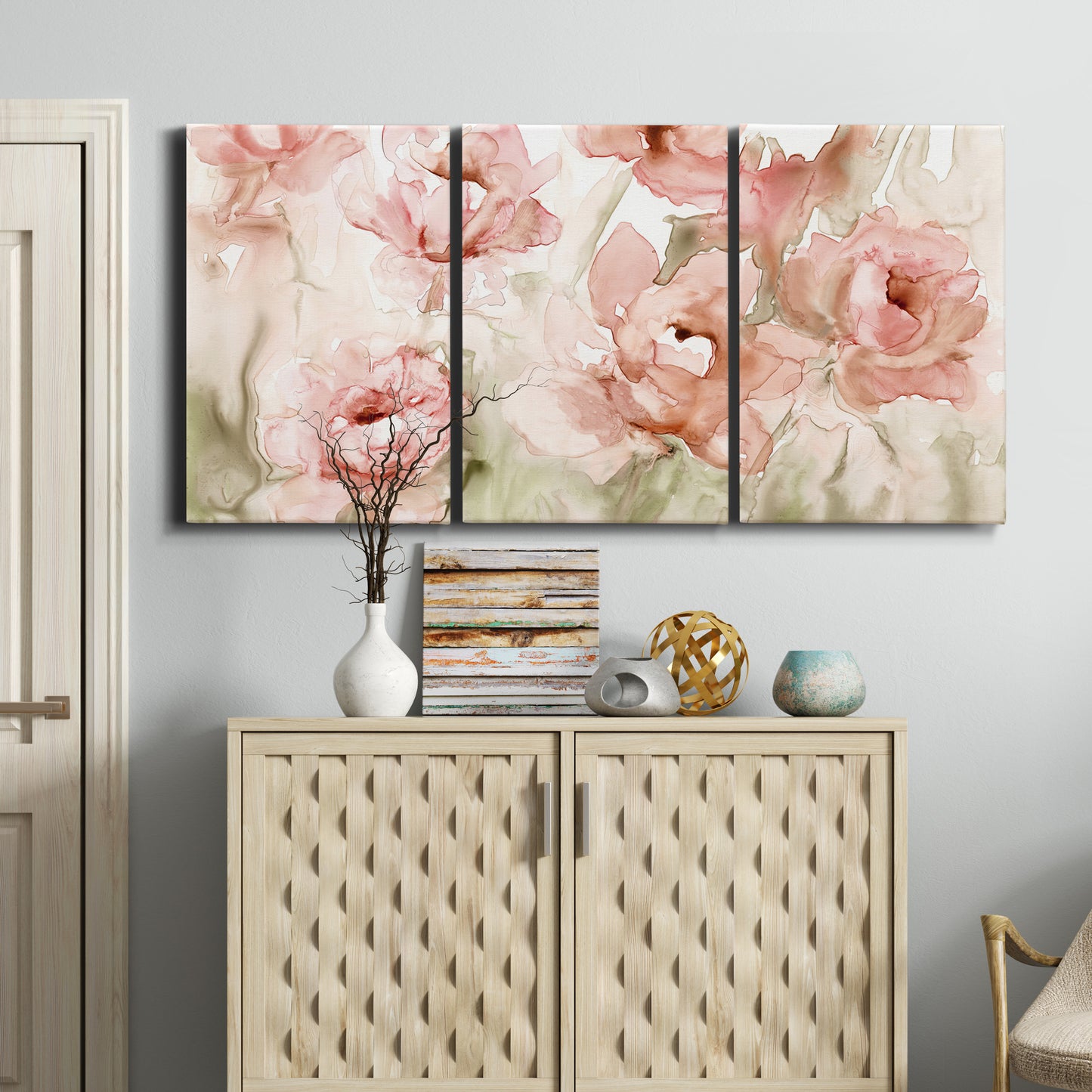 Three-panel canvas wall art featuring spring floral blossoms in bloom, displayed above a cabinet in an entryway.