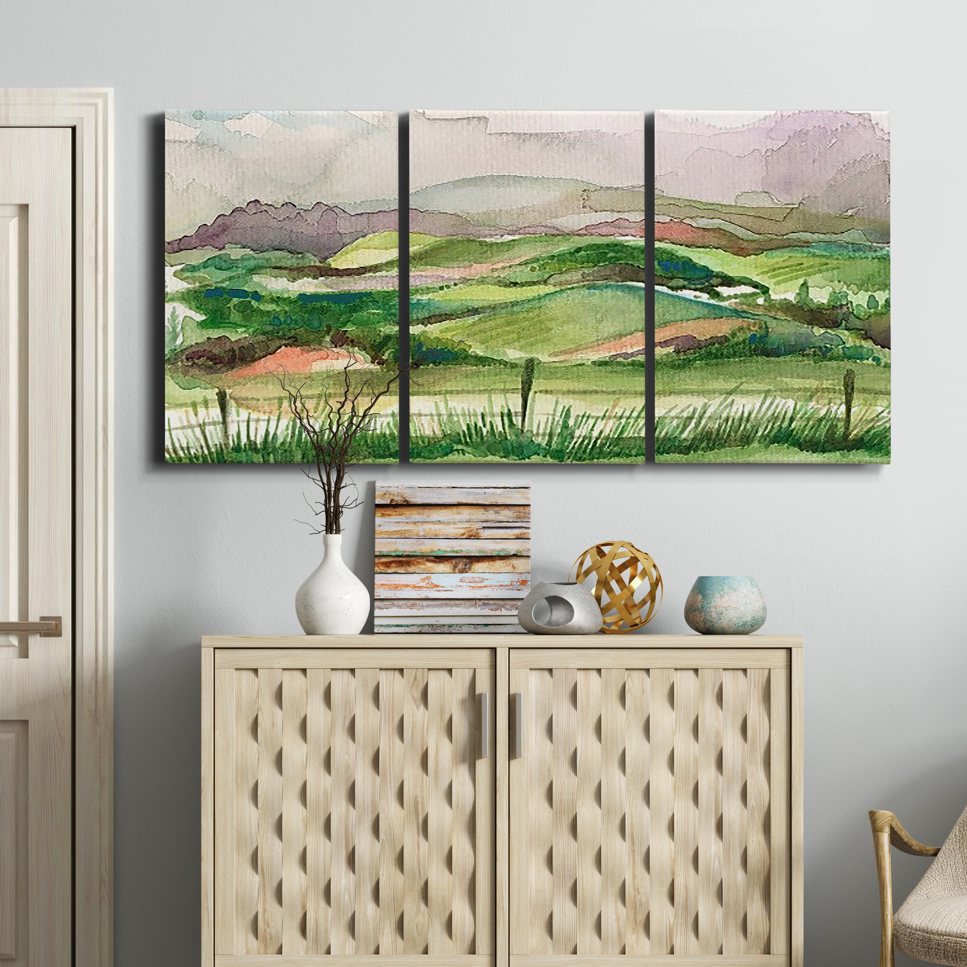 Three-panel canvas wall art featuring rainy landscape with soft atmosphere, displayed above a cabinet in an entryway.