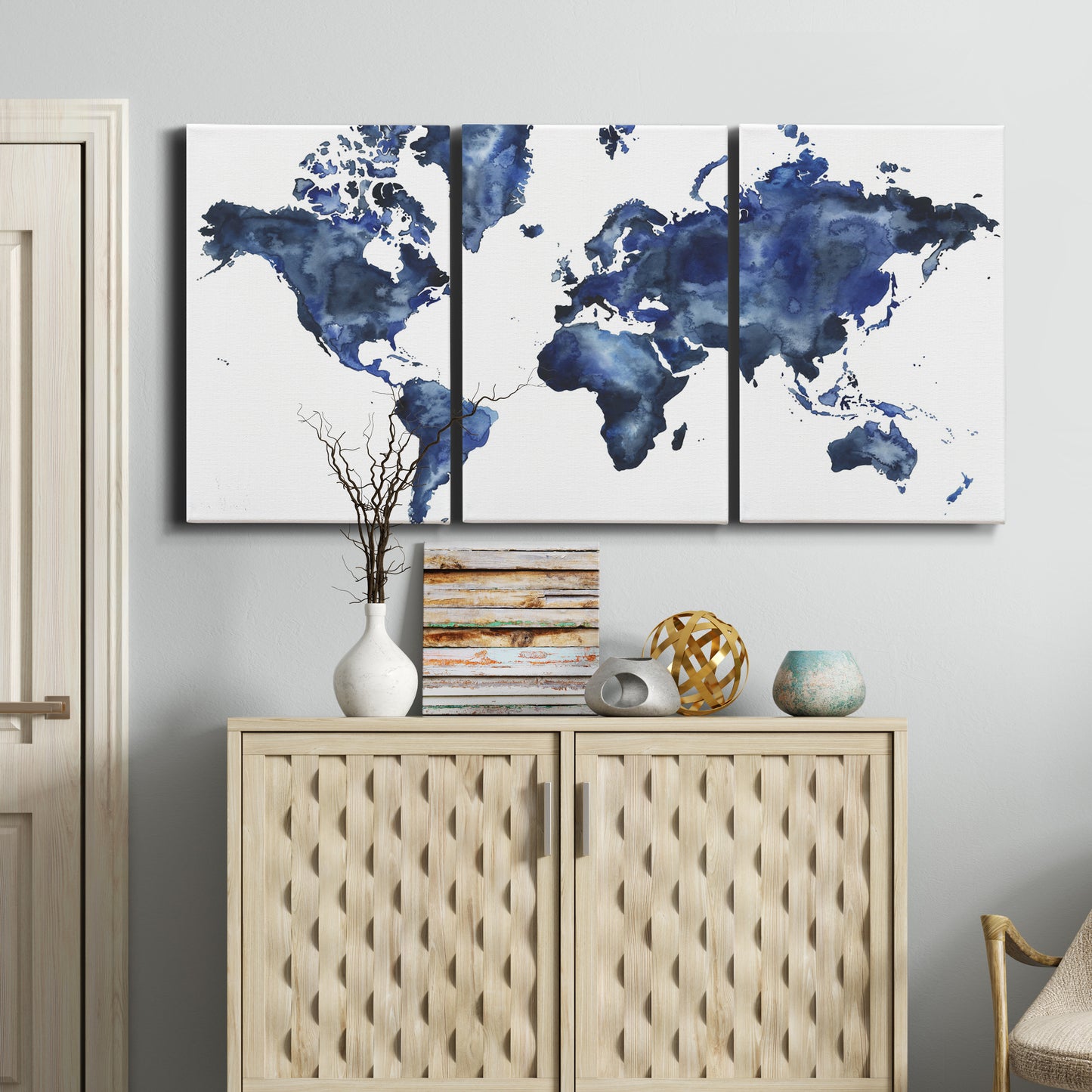 Three-panel canvas wall art featuring world map with water motif, displayed above a cabinet in an entryway.