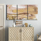 Three-panel canvas wall art featuring layered abstract dawn tones, displayed above a cabinet in an entryway.