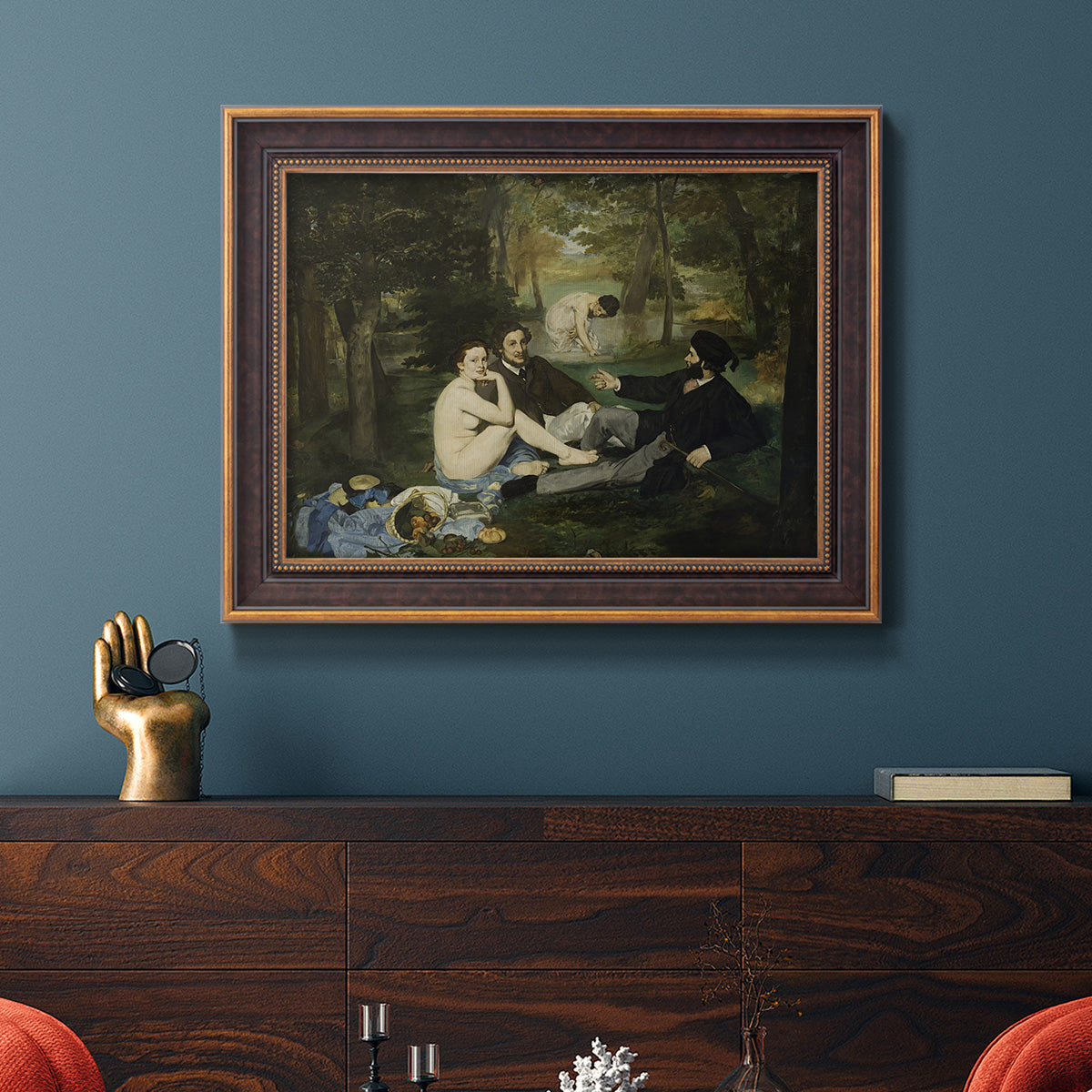 Groundbreaking impressionist picnic scene by Édouard Manet in an ornate bronzed mahogany wood frame displayed in a dark-toned interior setting.