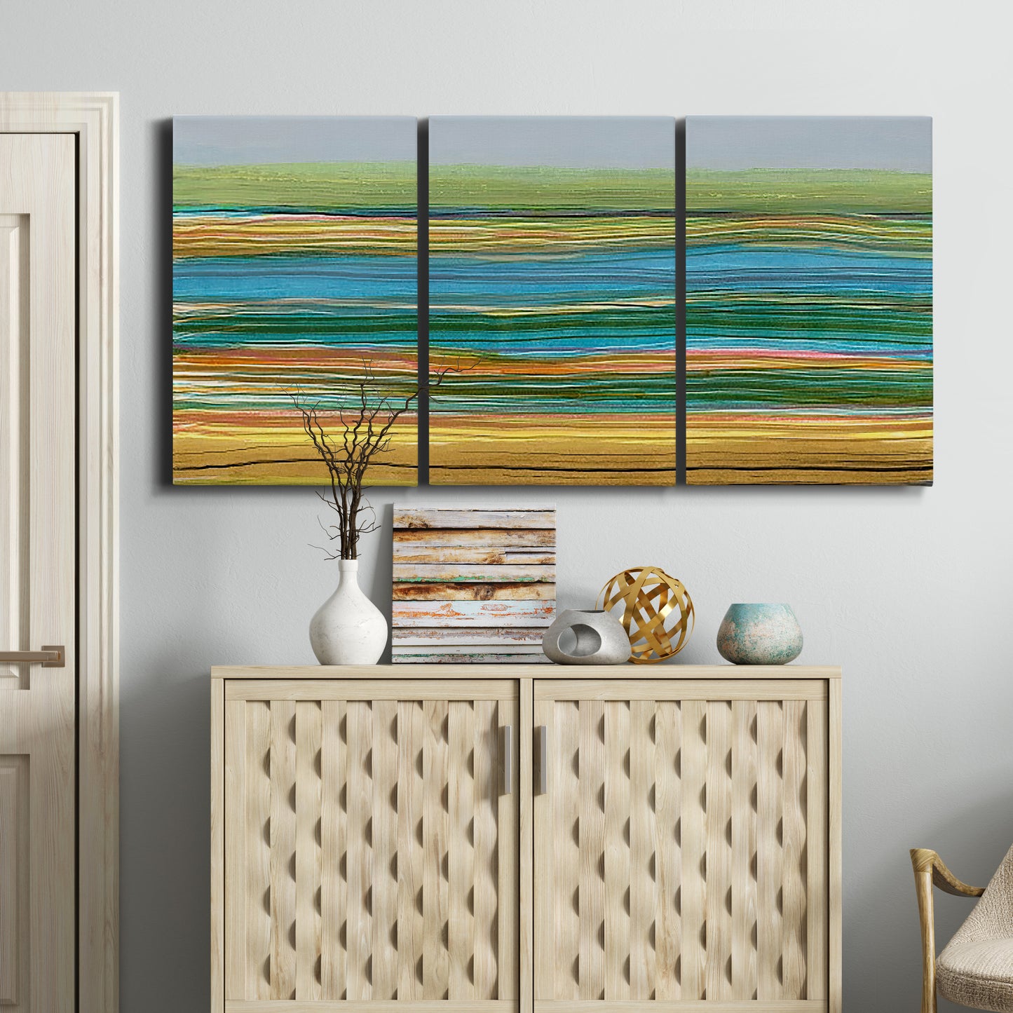 Three-panel canvas wall art featuring parallel linear abstract striations, displayed above a cabinet in an entryway.