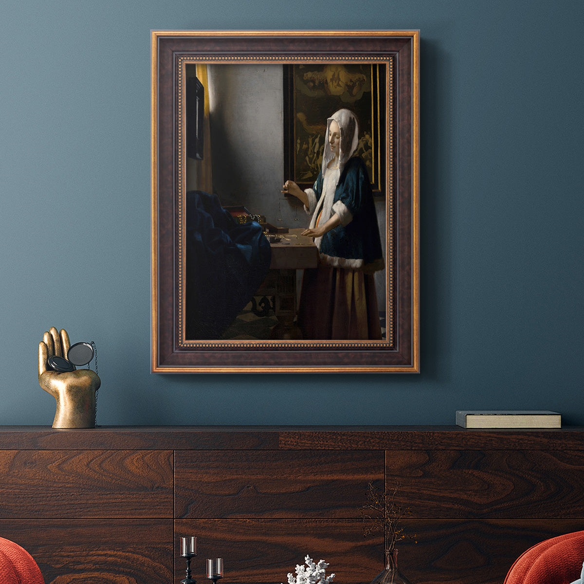 Quiet interior genre scene of a woman with scales by Johannes Vermeer in an ornate bronzed mahogany wood frame displayed in a dark-toned interior setting.