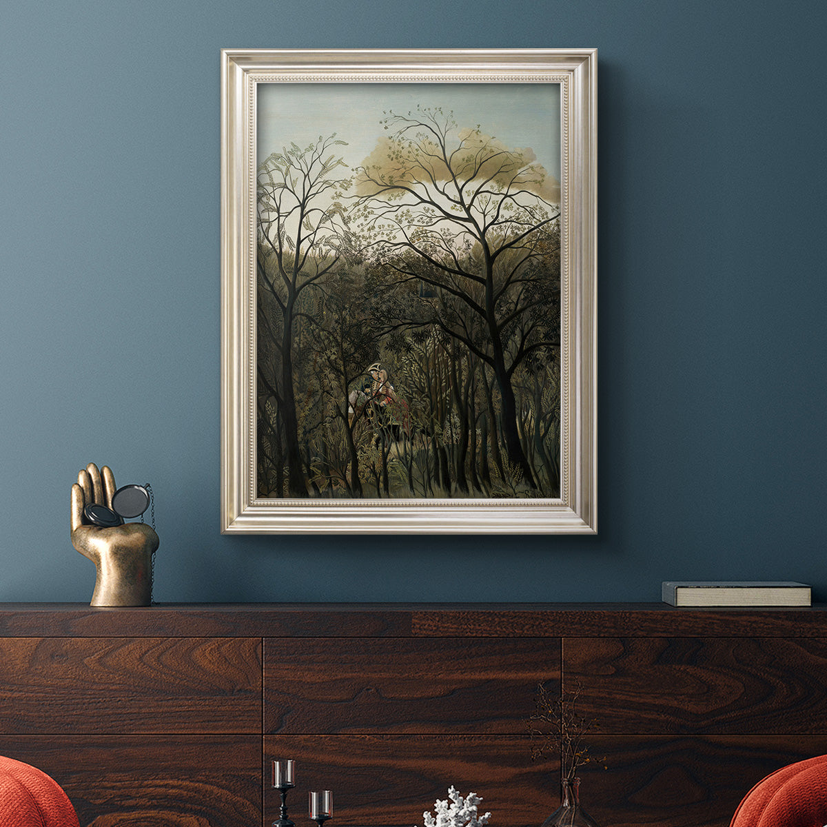 Dreamlike forest landscape scene by Henri Rousseau in an ornate champagne frame displayed in a dark-toned interior setting.