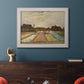 Impressionist Dutch bulb field landscape by Vincent van Gogh in an ornate weathered white frame displayed in a dark-toned interior setting.