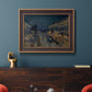 Impressionist nighttime Paris street scene by Camille Pissarro in an ornate bronzed mahogany wood frame displayed in a dark-toned interior setting.
