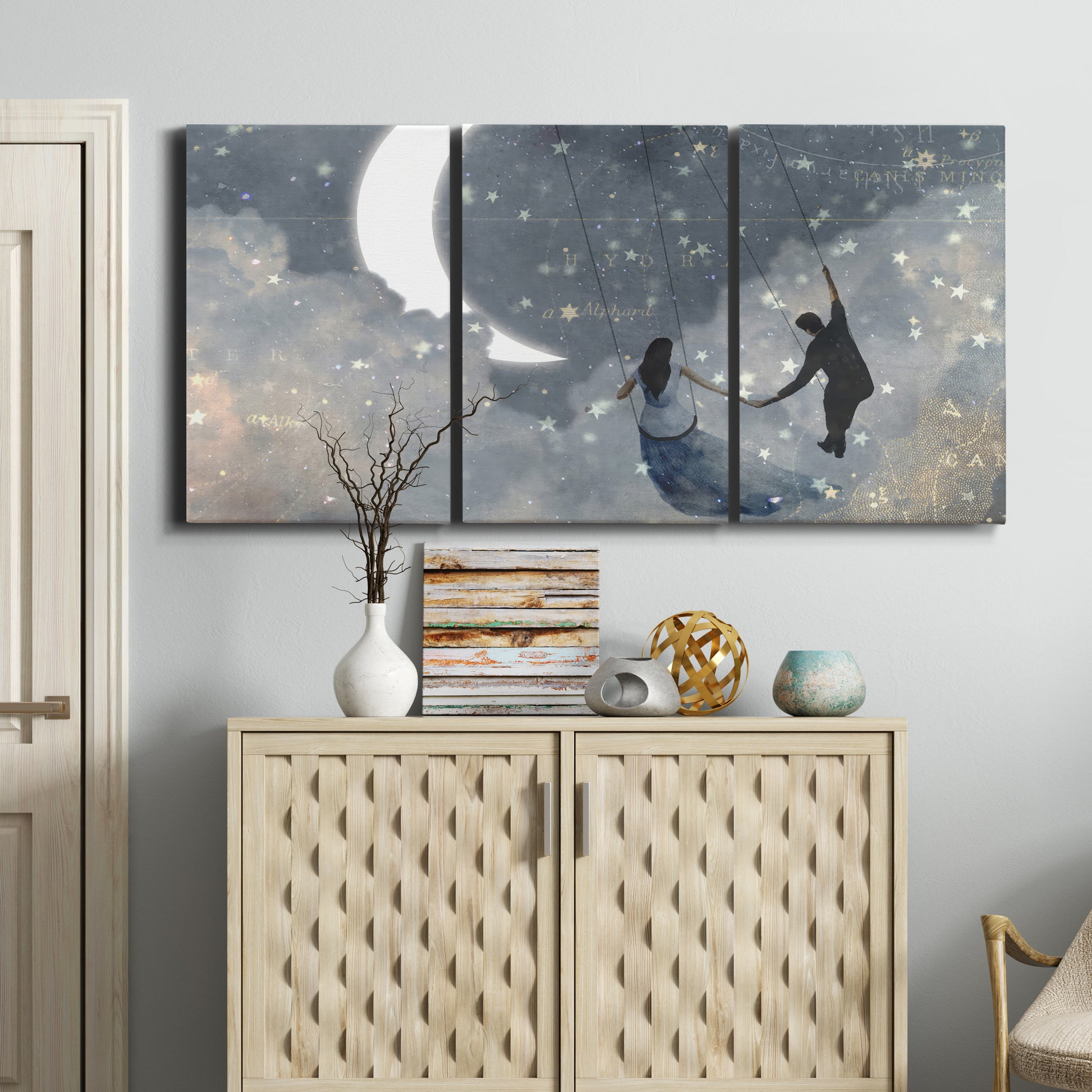 Three-panel canvas wall art featuring surreal celestial romantic scene, displayed above a cabinet in an entryway.