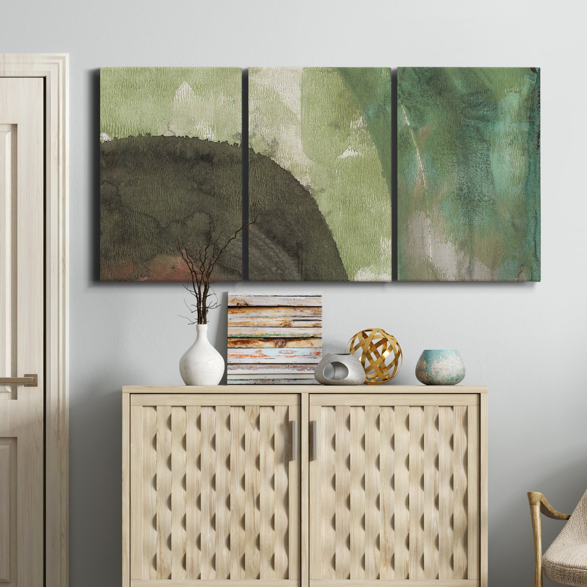 Three-panel canvas wall art featuring layered green abstract composition, displayed above a cabinet in an entryway.