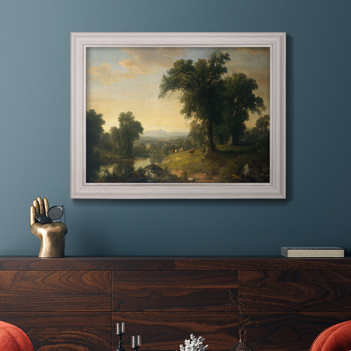 Traditional pastoral landscape painting by Asher Brown Durand in an ornate weathered white frame displayed in a dark-toned interior setting.